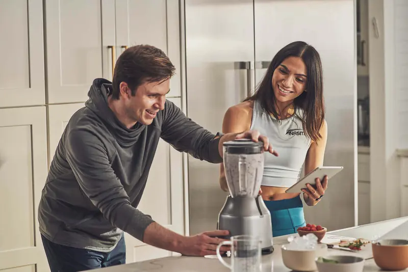 A couple preparing a healthy smoothie together in a kitchen